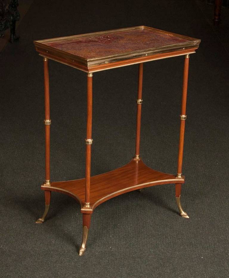 A French late 19th century Directoire style occasional table with gilt bronze gallery surrounds and red onyx top.  Table rises on gilt bronze bifurcated feet.    .