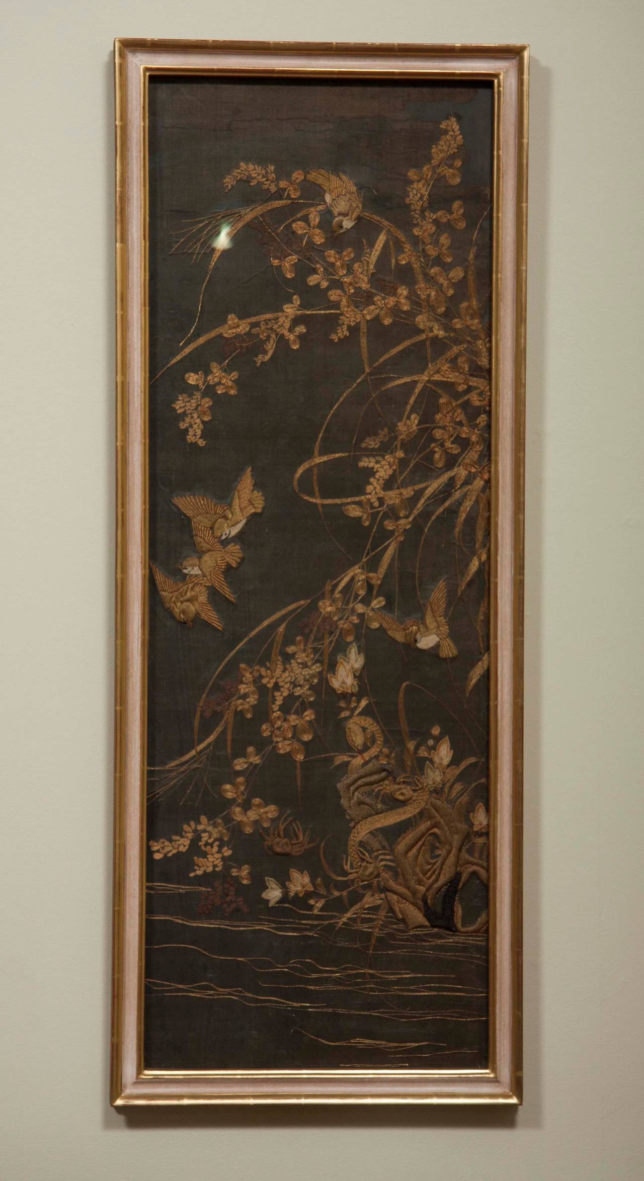 Four framed Japanese embroidered silk panels with metal thread decoration of birds in trees and flowers.