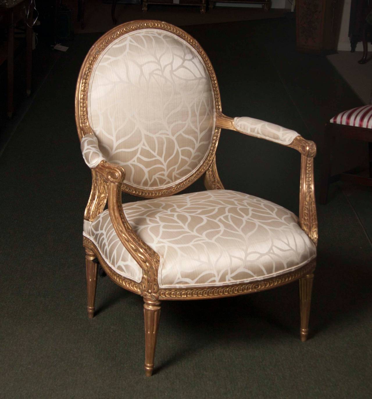 A pair of Louis XVI style fauteuils with fabulous water gilding and exceptional upholstery.