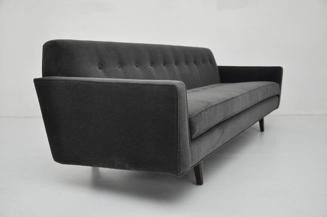Bracket back sofa designed by Edward Wormley for Dunbar circa 1950's. Fully restored. Refinished walnut bases. Newly upholstered in dark grey mohair.