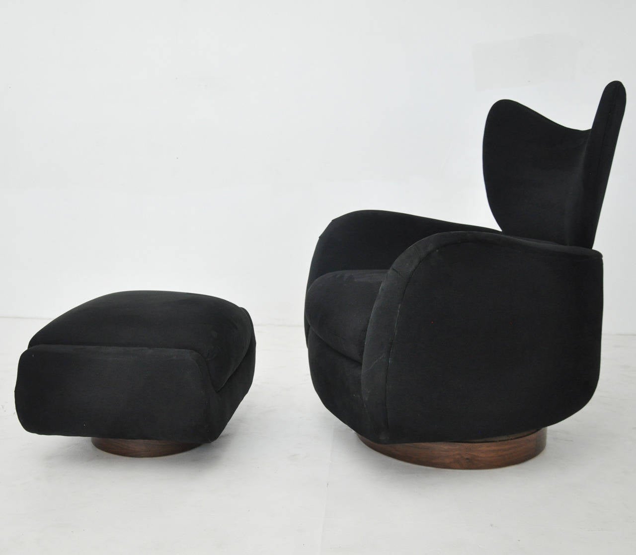 Swivel lounge chair with ottoman. Designed by Vladimir Kagan for Directional. Original upholstery with walnut bases. Chair swivels and rocks.