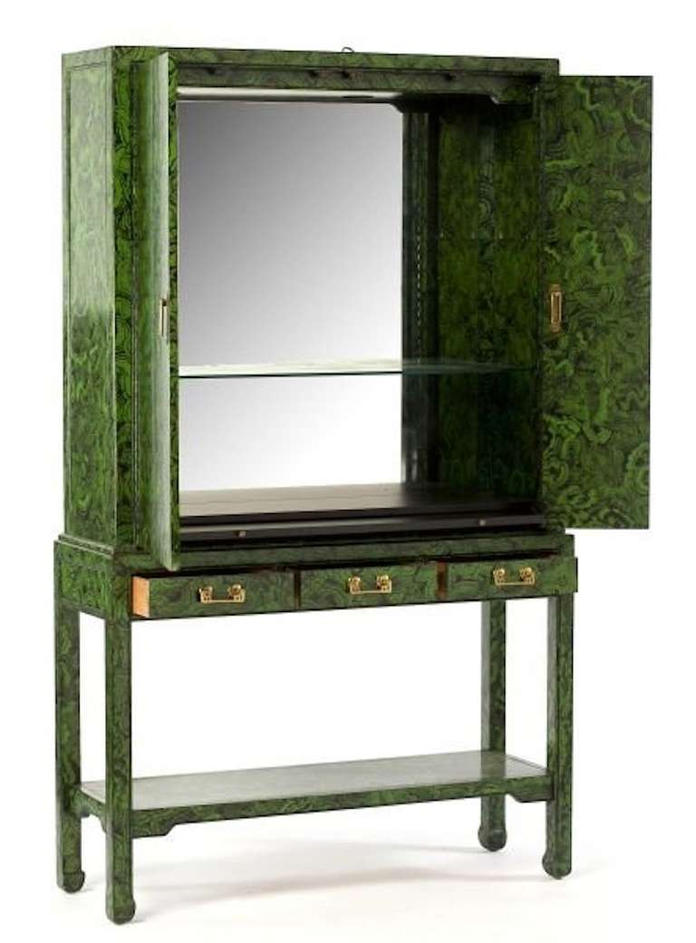 Hand painted faux malachite bar.  Two part form.  The top with two folding doors, mirrored and lighted interior with single shelf, the lower portion with three drawers over an open shelf, brass hardware.