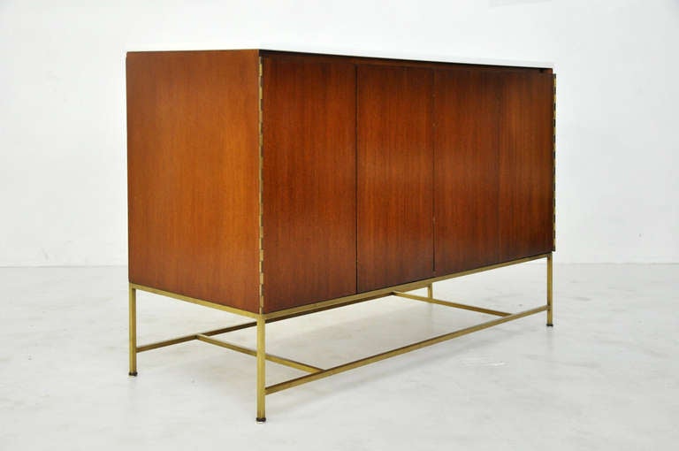 Paul McCobb designed sideboard for Calvin Furniture. Brass frame base with white Vitrolite glass top.