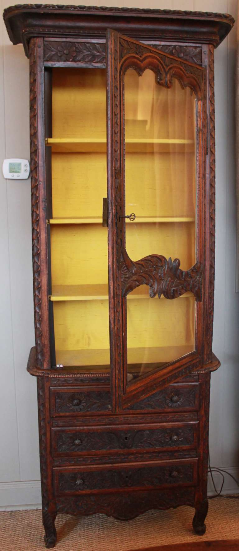 Wonderfully carved cabinet from France. Top has cabinet door with shelves that are lined with fabric. A light has been installed. Bottom has three drawers. This piece would work great in smaller spaces such as powder room, entry, hallways or