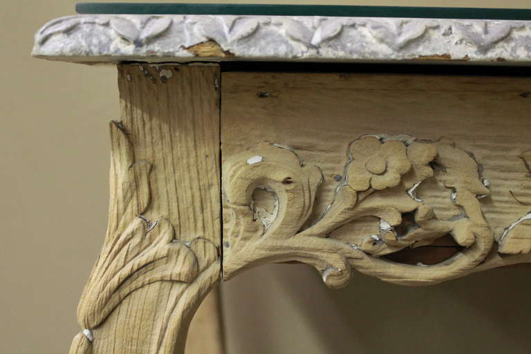 Beautifully carved French table with floral design. The base has been stripped to natural finish with original painted faux marble top. Very gracefully shaped legs. This is a special piece!