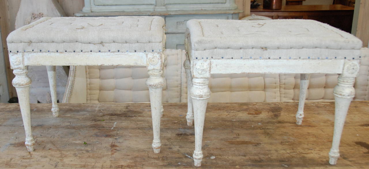 Lovely pair of Swedish Gustavian footstools with tapered carved legs. Newly upholstered in Antique hemp.