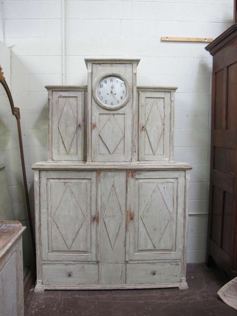 Very nice 19th century Swedish cupboard. Great cupboard for storage with four paneled doors that open to shelves and two drawers down below. Scraped down to the original grey/ white color. Comes with original weights and pendulum. c1810