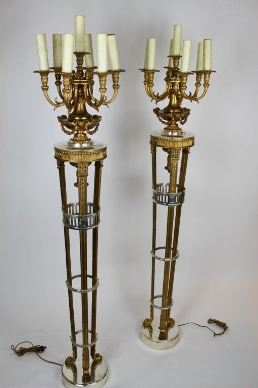 Caldwell, a pair of doré and silvered bronze tripod form floor lamps on conforming marble bases. The seven-armed candelabra are carried on neoclassic urns decorated with rams' heads and laurel wreath swags.

Caldwell and Co. were America's
