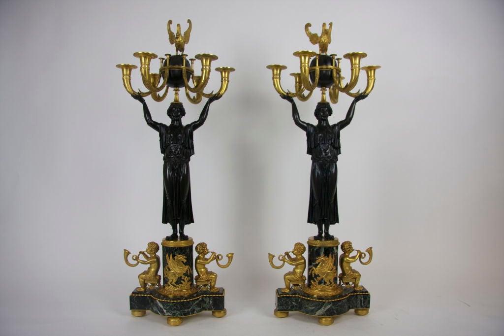 An important pair of Russian Empire Figural patinated and Dore Bronze six-light candelabras with maidens and putties with verde antico marble bases.  Each candelabra with a standing patinated empire figure of a maiden with open arms holding the five