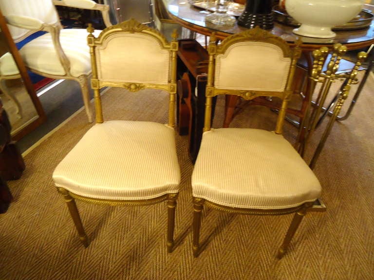 Carved gilt wood, newly upholstered seats and back in gold and cream striped silk.  Small and lovely chairs. 

Seat is 22