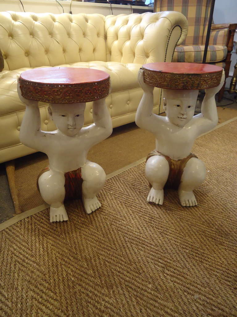Asian flair, carved decorative wooden small tables, perfect for a drink.  The bases are cherubic Asian Buddhas, colors are cream, red and gold; inset decorative mirrors around the gallery on table tops.  Enchanting!