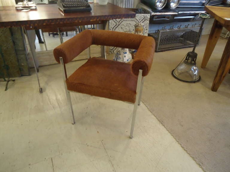 Sophisticated and fun chrome midcentury armchair, newly recovered in rust brown cowhide.  Make a very stylish desk chair, or an extra living room chair.  Comfortable and chic.