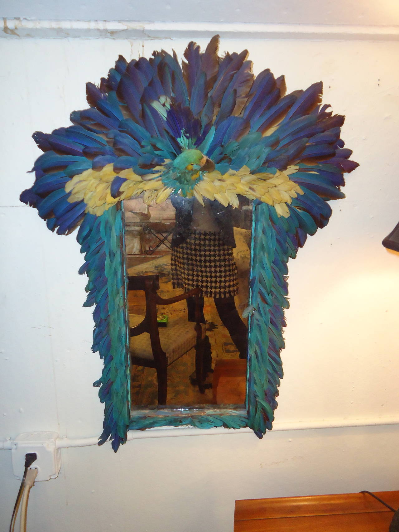 Hand created by famed NY Times photographer Bill Cunningham, signed on the reverse and dated 1968. Aged mirror is framed in bright blue and cream colored feathers and the taxidermy head of a tropical bird.