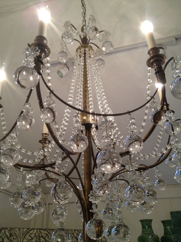 Very unusual glamorous brass chandelier adorned with multiple large round crystal balls and strands of crystal 