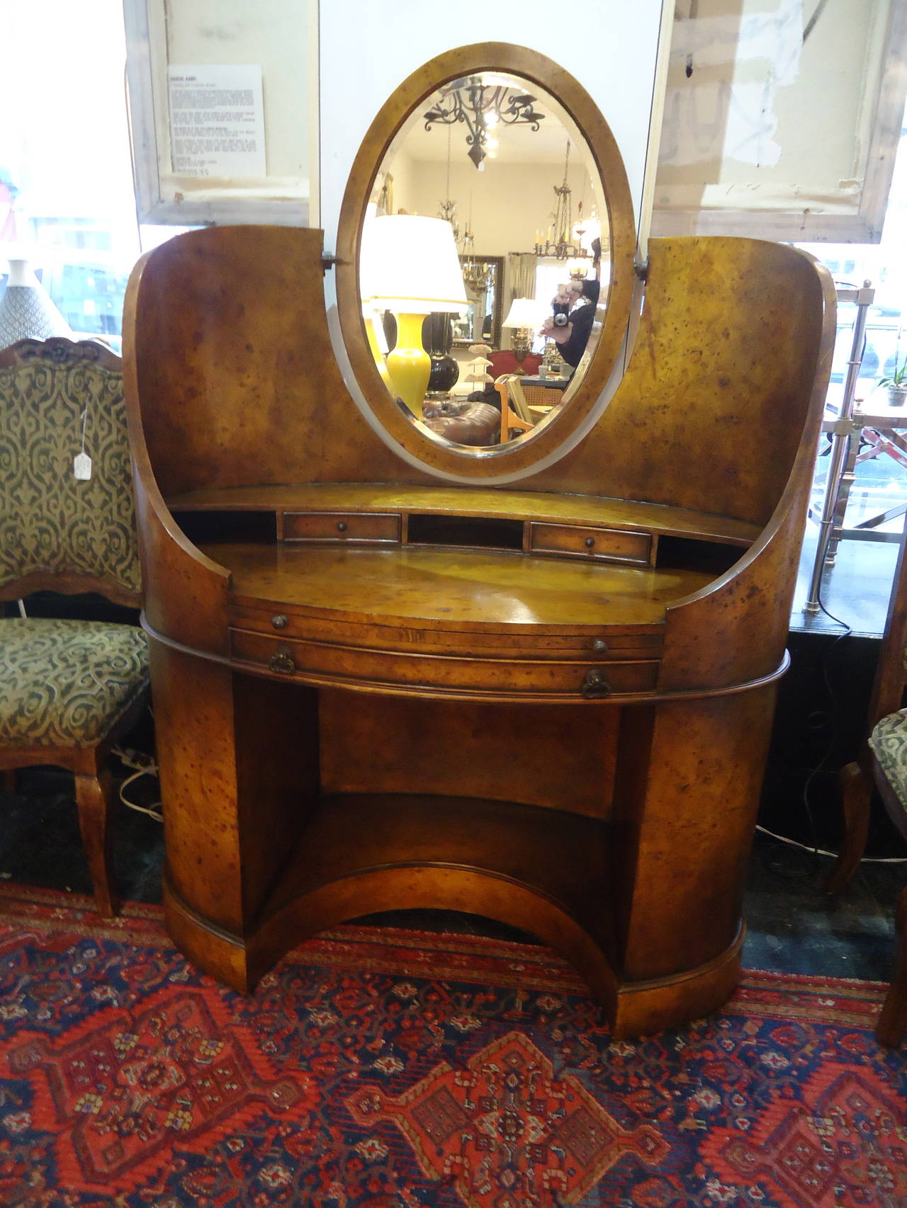 Sensationally curved, elegant burl wood vanity, tooled leather pull-out writing surface, two little drawers (one may be missing), cubbies and oval mirror. Original bronze hardware.