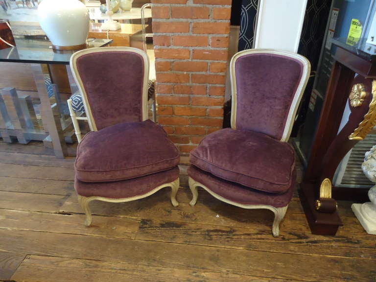 Very low to the ground, romantic little chairs, perfect for a lady's bedroom or fancy livingroom.  Cream slightly chippy painted wood frames, cabriole short legs, and luscious eggplant soft high pile velvet. Cushions are down, of course! Oooooh la la