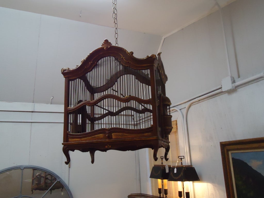 Beautiful carved and gilded walnut birdcage, mesh screen and sliding bottom drawer
