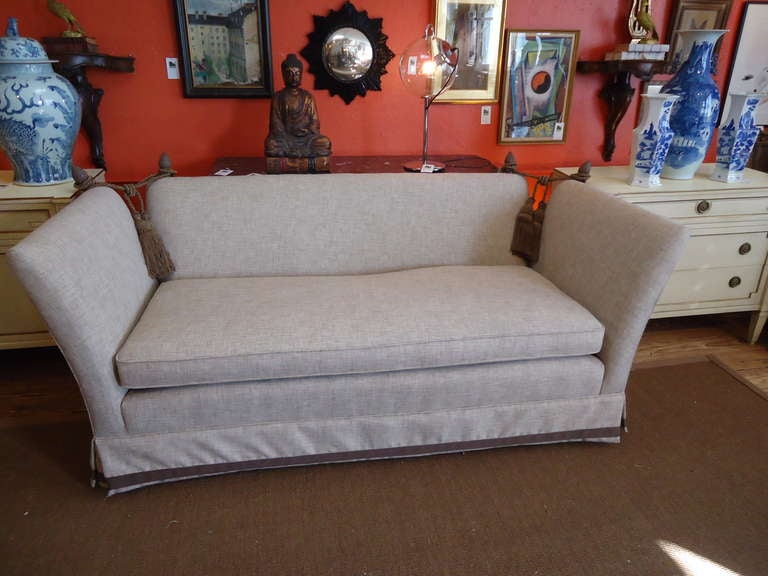 Vintage knole style sofa, newly upholstered in a neutral linen, finials and tassles in the top corners, perfect condition, grosgrain ribbon band around bottom of skirt, stunning!
Seat is 24.5