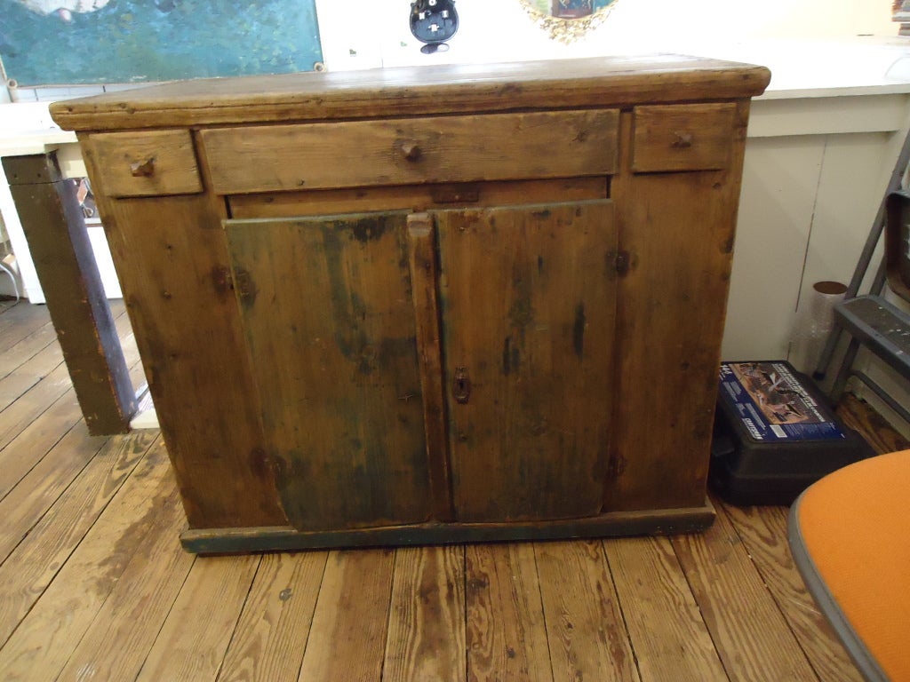 Wonderful authentic primitive piece. <br />
There are three drawers at the top of the cupboard, two small and one large. <br />
 2 doors for storage underneath. The knobs on all doors and drawers are hand carved and in good condition.