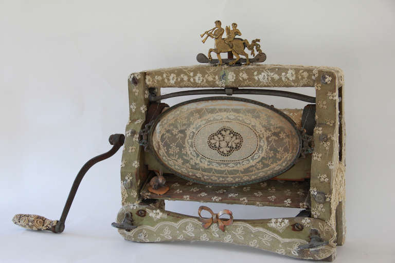 A wonderful old laundry mangle or wringer with original faded green paint is a lace adorned sculpture called 