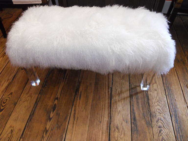 Custom ottoman with lucite legs and Mongolian lamb top