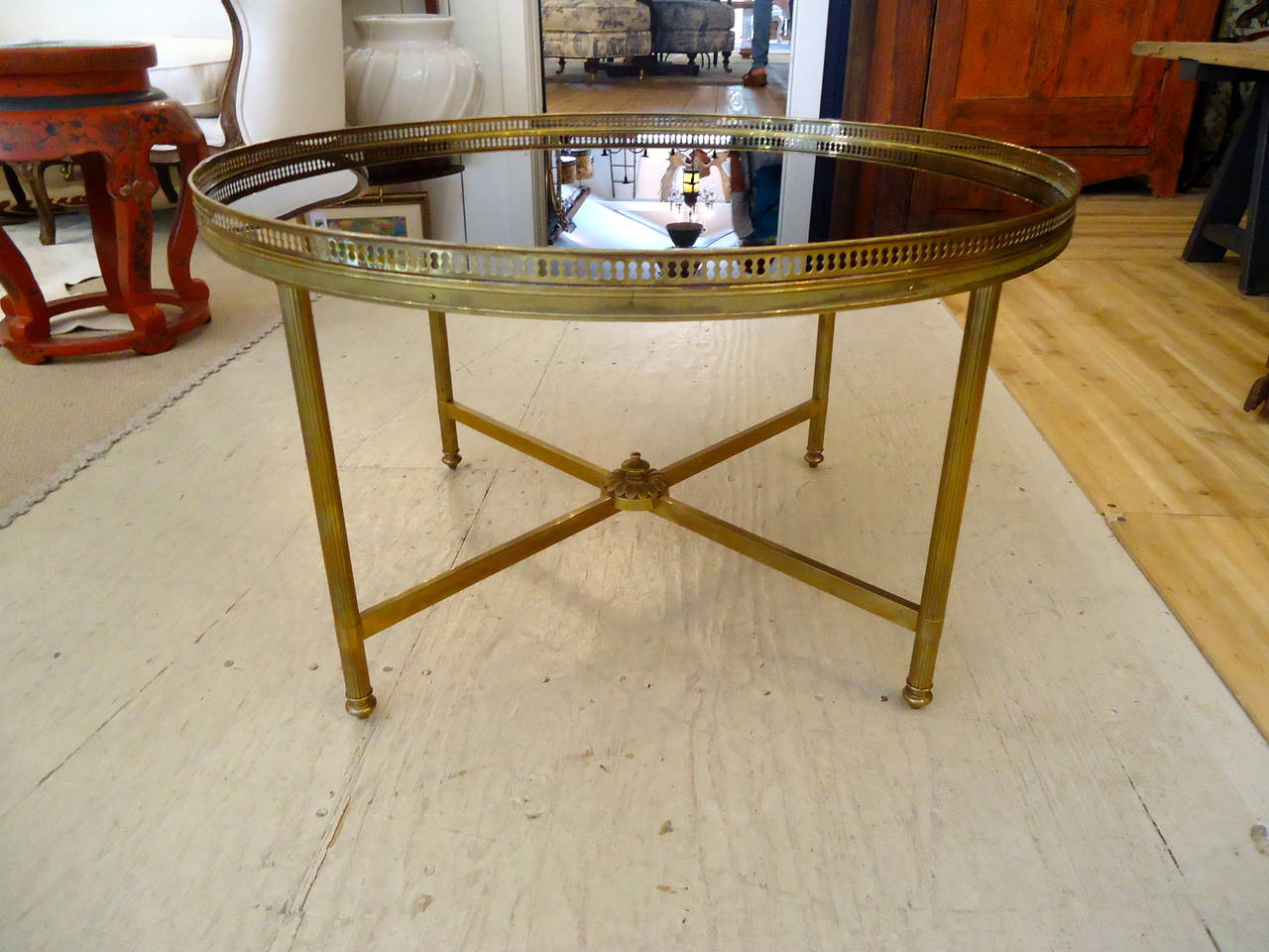 Great apartment sized round gem of a bronze/brass coffee table with reticulated gallery and elegant reed decorated legs and black glass top.