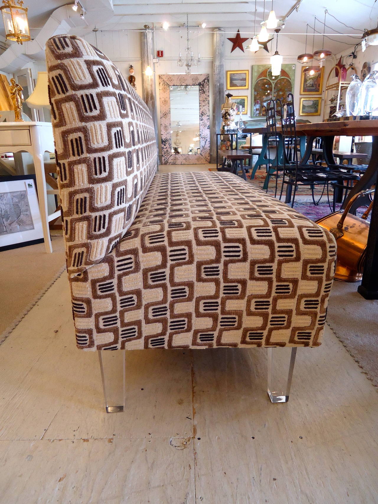 Fabulously stylish armless loveseat upholstered in a textured geometric fabric and sitting on four Lucite legs.
Seat depth and height 20