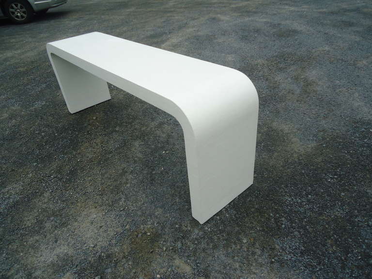 Modern sleek design, low slung console or sofa back table.  White linen wrapped.