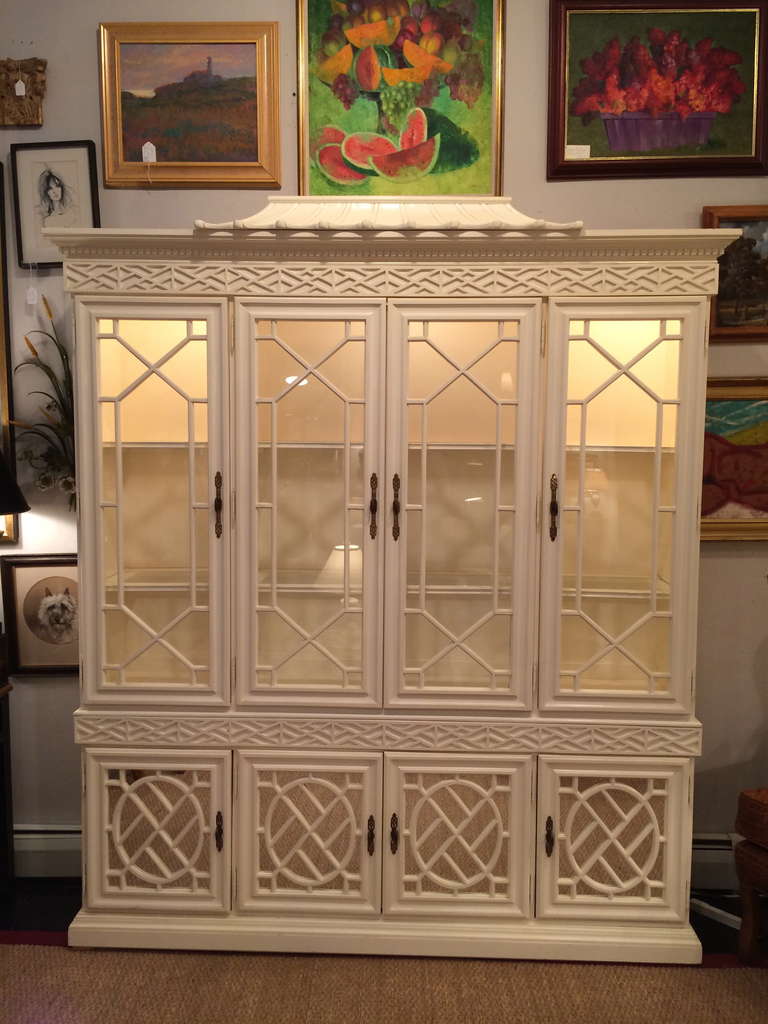 Hollywood Regency Chinese Chippendale Pagoda Top White Lacquer Cabinet having glass fretwork doors above and mirrored fretwork doors below with shelving for storage.  
77