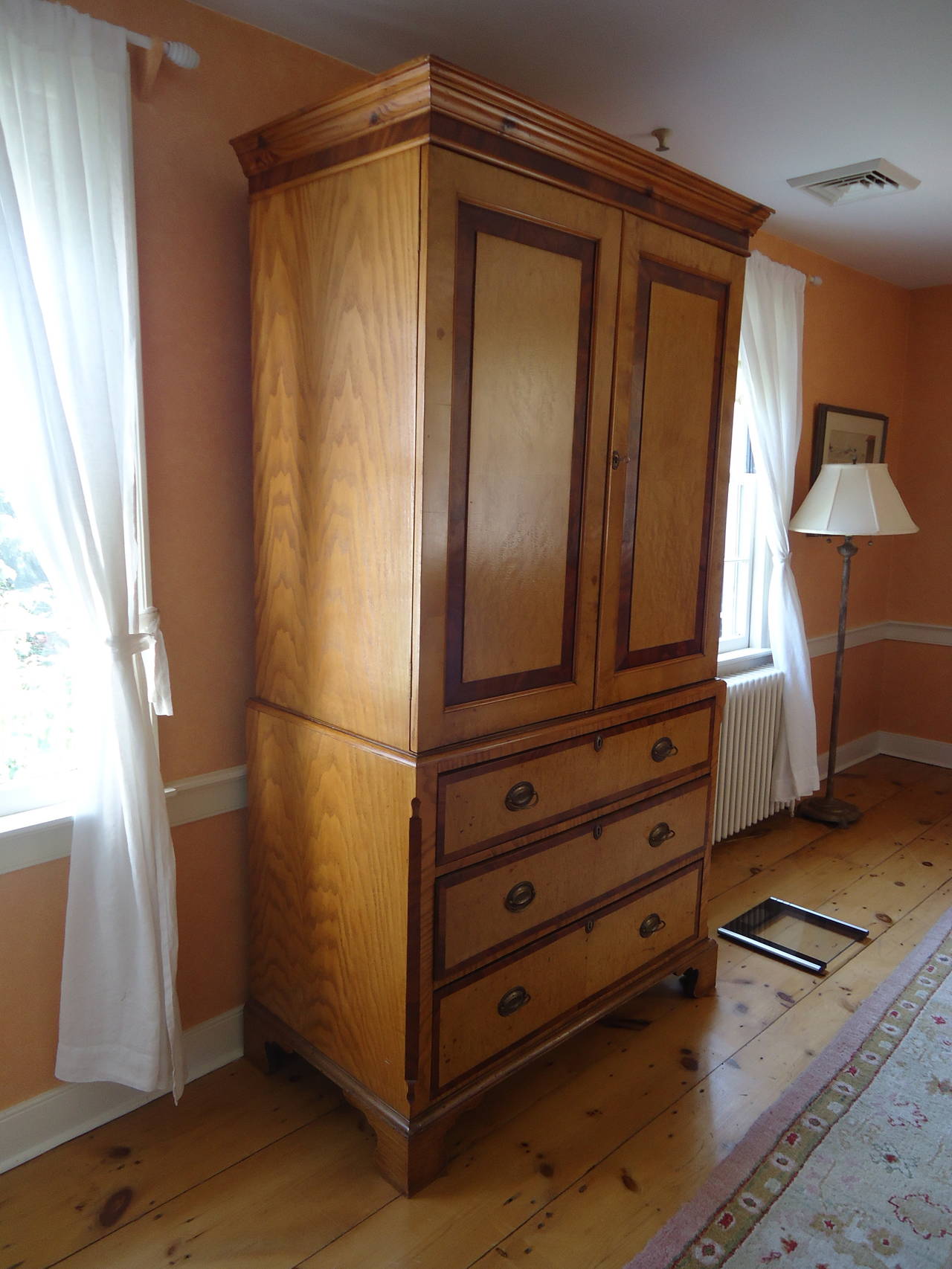 Large armoire in dark and light wood with original hardware having a top section which opens by a key to three large shelves within, 20.5 D x 38.5 W.
Bottom is a commode with three roomy drawers that all work smoothly.