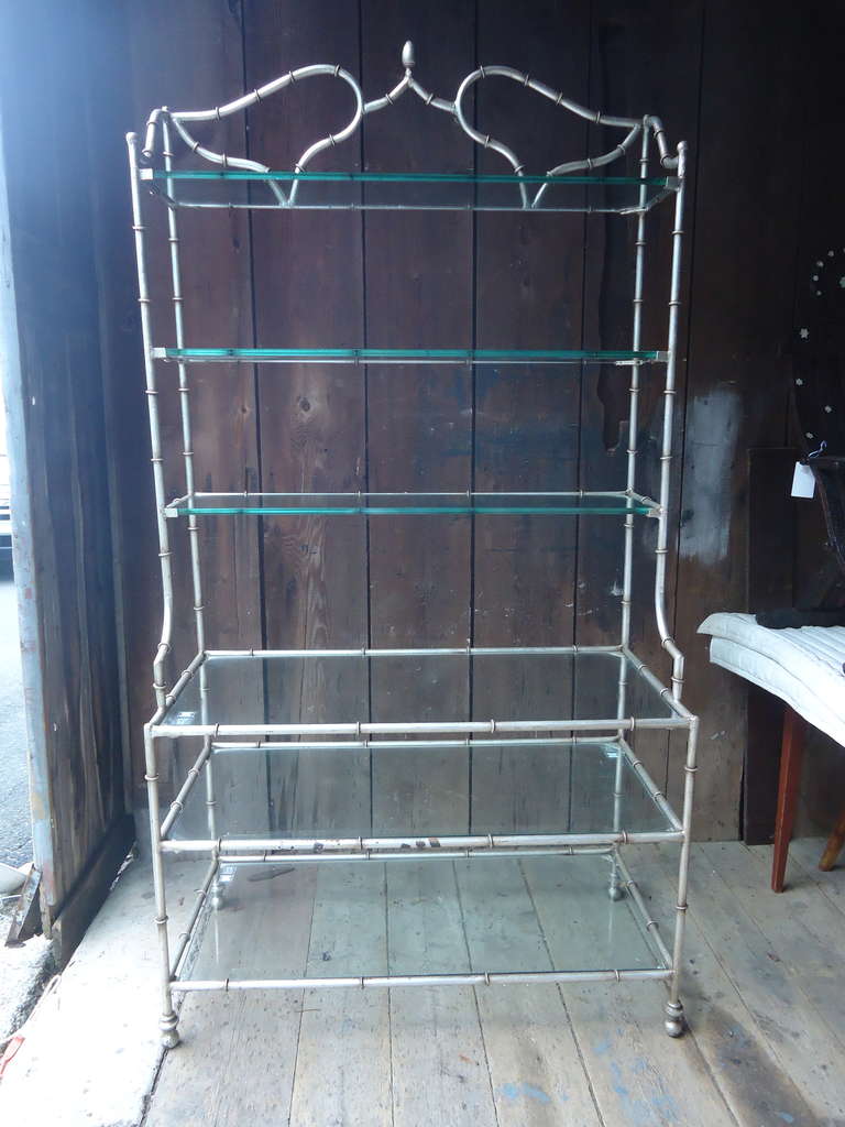 Unique form with a step back style. Gilded metal with 6 custom cut glass shelves. Has a nice worn rustic silver gilt patina.
Shelves are 11