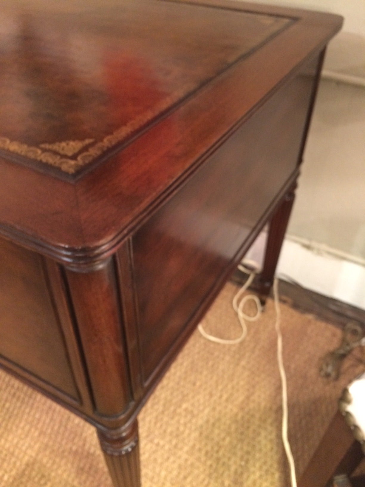 Beautiful early 20th century Kittinger desk having five drawers and original brass knobs, rich brown tooled leather top with gold decoration.  The back of the desk is finished as well, but the drawers only work from the front.