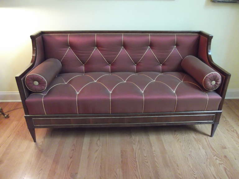 A Baltic Neoclassic Yew-wood and parquetry sofa with brass insets.
An elegant box form with brass mounted panels throughout, plum silk upholstery with corded tufting.