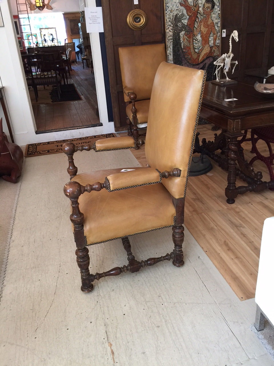 Very handsome continental armchairs having light brown leather and carved mahogany.  
Seat width 27