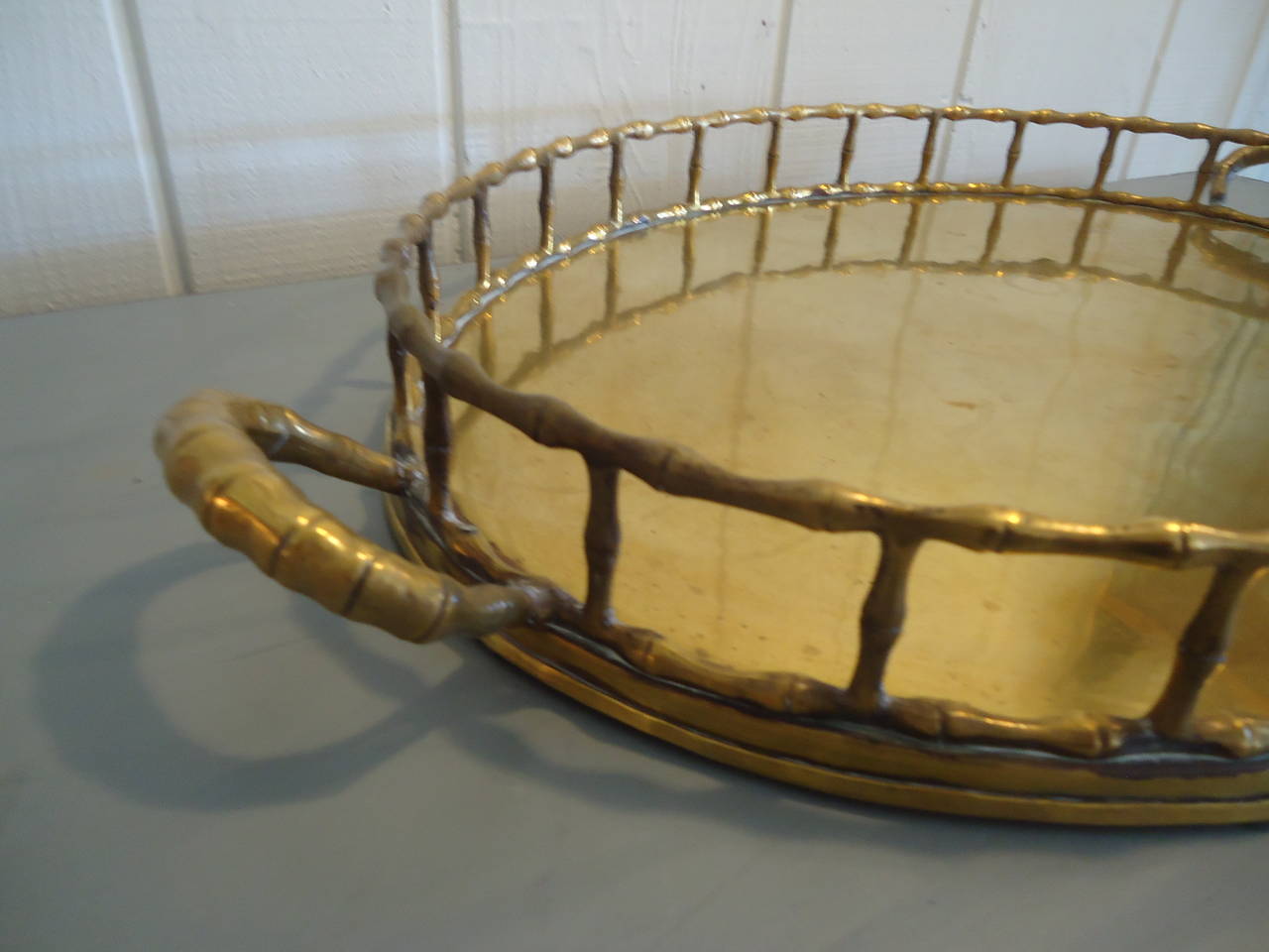 Large oval brass tray having faux bamboo motiffe and chunky decorative handles. Age appropriate patina.
Dimensions: Tray itself 23 L,
with handles 27.5 L.
