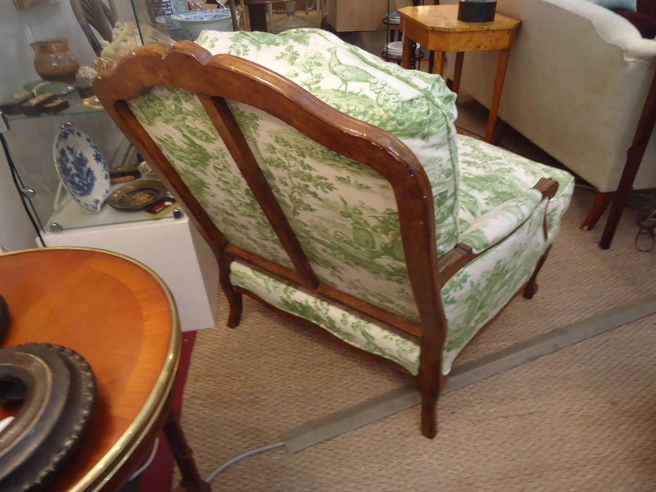 Oversized French bergere style chair, carved walnut and upholstered in a charming green and white toile.