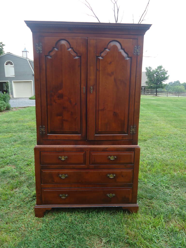 A very large handsome wooden cabinet; 4 drawers on bottom; 2 doors on top that open to a large open armoire outfitted with sliding panel for tv set 29