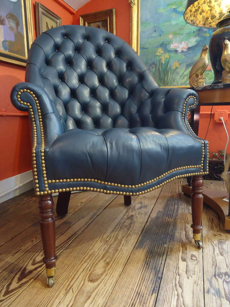 Wonderful shade of prussian blue leather, tufted on inside seat and back, smooth on other side.  Mahogany legs and capped feet with brass casters.
Handsome nailhead detailing.  Attributed to Ralph Lauren, but tag removed.