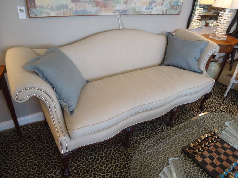 Classic camelback Chippendale style couch, newly upholstered in a neutral
sand colored linen.  Beautiful carved walnut legs and base, silver nailhead detailing.
Width of seat from side to side is 77
