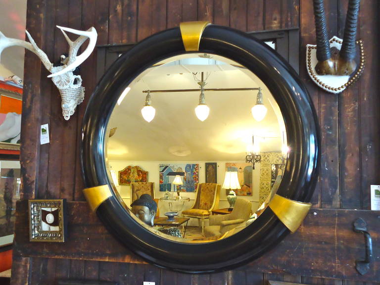 Big, chunky and round mirror.  Ebonized black frame with 3 wide gold bands.