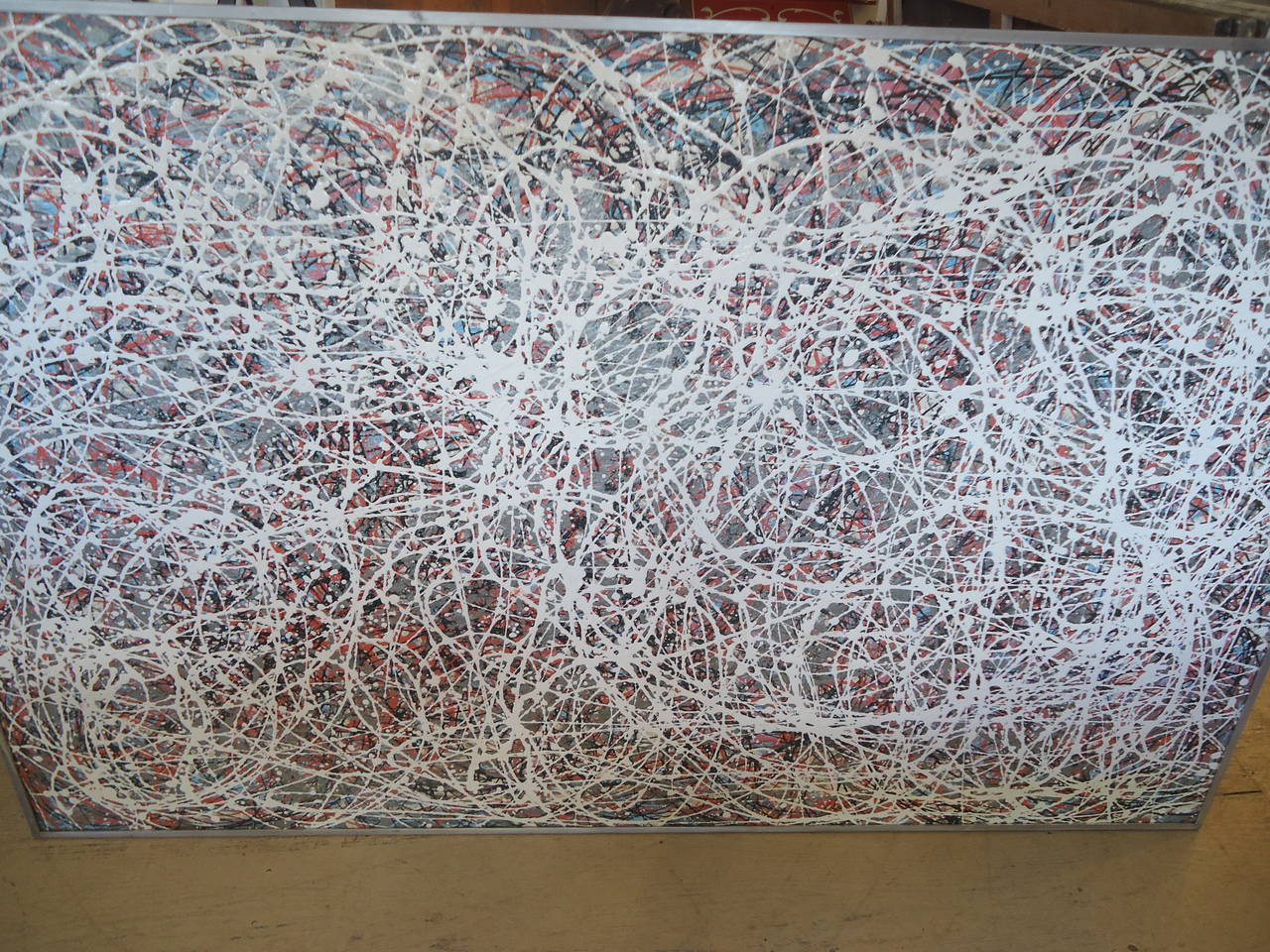 Striking large abstract expressionist painting in the style of drip painting that Jackson Pollock made famous. Pewter grey, white, coral, blue and black make up the color palette. Custom steel frame. No signature.