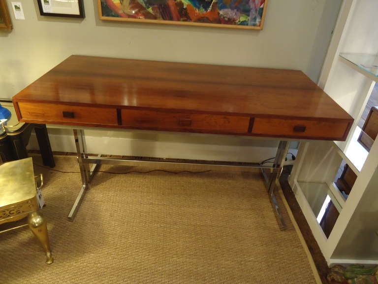 Danish Modern at its best.  Glossy gorgeous Brazilian Rosewood, desk model #3520. Label in left drawer, three drawers. Chrome special order base.