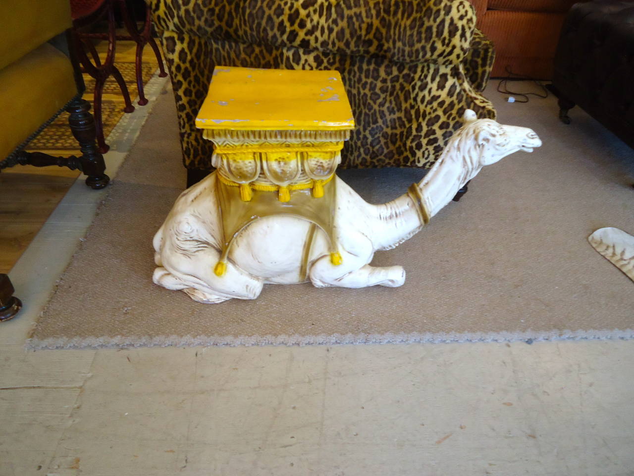 Wonderful theatrical terracotta drinks table or garden seat in the shape of a white kneeling camel with Moroccan style seat/tabletop on her back in a chippy yellow gold color. Could be easily painted, but the distressed appearance gives it age and