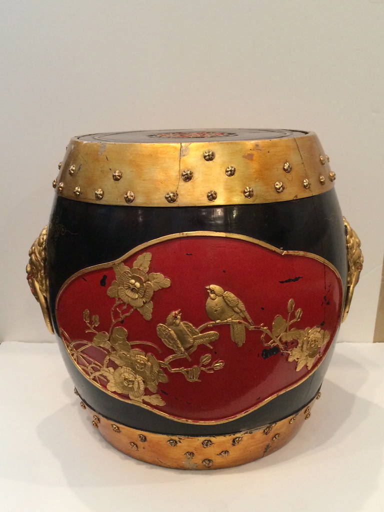 Very unusual ornate barrel shaped wooden rice/tea caddy black ground with blood red decoration and raised gold leafed birds and foliage. Tops and bottom are encircled in gold studded bands; Foo dogs with rings adorn the sides. Top comes off and seat