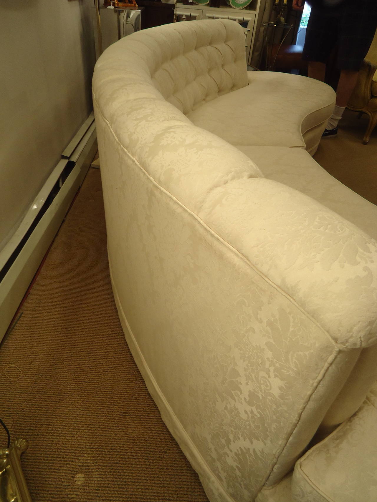 Curvy in all the right places, Hollywood Regency style sofa from the 1970s with tufted back, covered in off-white damask fabric and gorgeous from the front and back.