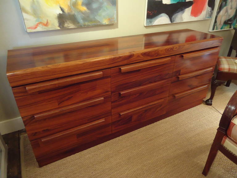 Mouth watering rosewood veneer with gorgeous colors and graining. Simple and elegant Mid-Century Danish design. Handsome wooden pulls on each of the six drawers. Lots of storage, but this is more than a dresser. Almost too beautiful to be hidden in