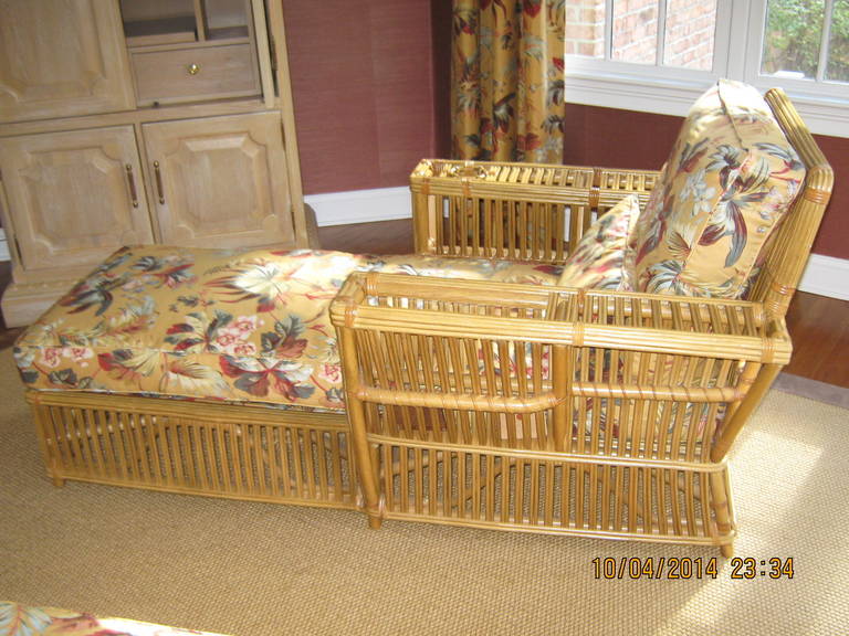 Pair of rattan chaise lounges by Bielecky Brothers, 1980s in mint condition, upholstered in a Brunschwig & Fils neutral floral fabric. One arm has a magazine rack, the other has a drink holder. Both have brass Bielecky Brothers labels.