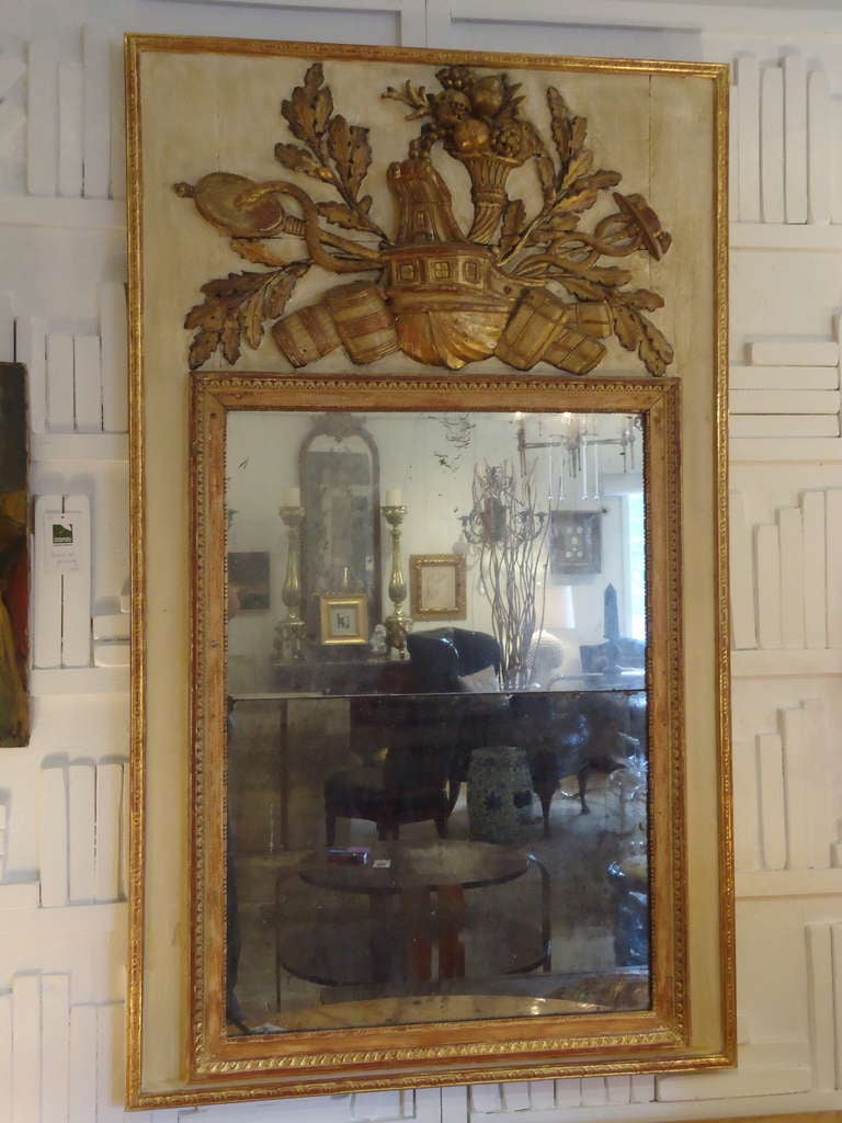 Wonderful aged distressed mirror framed in gold, then floated against a cream and gold ground with raised gilded decoration at the top.  Horizontal seam in middle of mirror dates this piece as early.  Anything reflected in the mirror becomes a