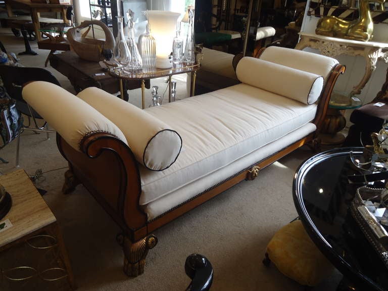 Light brown wood with ebonized black embellishments and gilding make a super starlet of a daybed. Newly reupholstered in white duck. Bolster pillows have black piping, a glam touch.