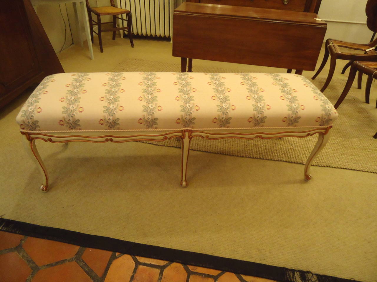 Painted wood base with 6 curvy legs; upholstered top in pastel floral fabric.
Nice long size, perfect at the end of a queen or king bed.